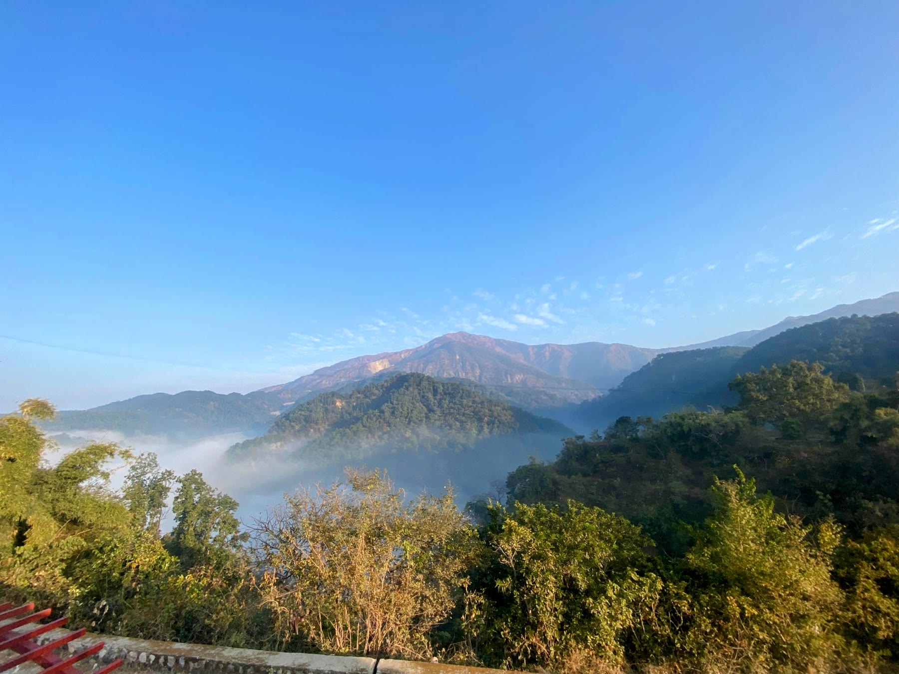 Morning fog resting between the mountains outside Amatā's upstairs balcony